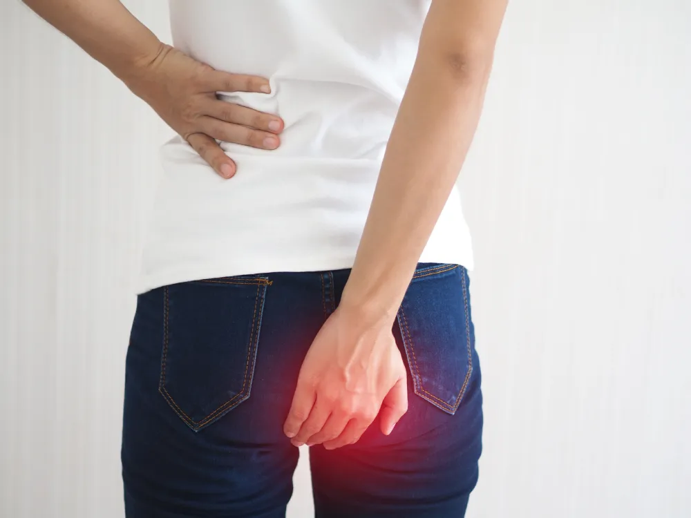 Woman suffering from anal fistula, pain is highlighted in red 